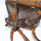 Close view of dog charm and gold-tone chain on backpack