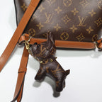Monogram dog keychain hanging upright from a brown bag