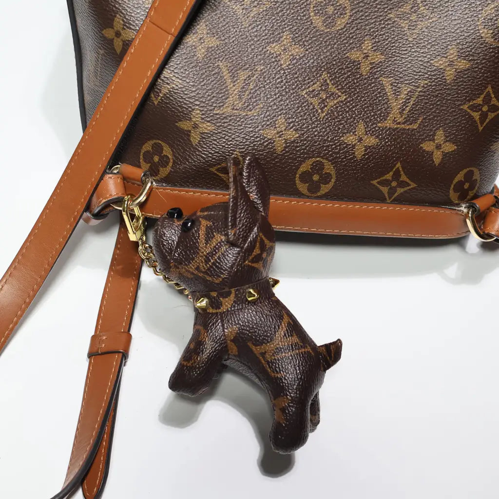 Monogram dog keychain hanging upright from a brown bag