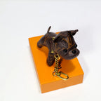 Brown monogram dog keychain showing face and gold-tone chain