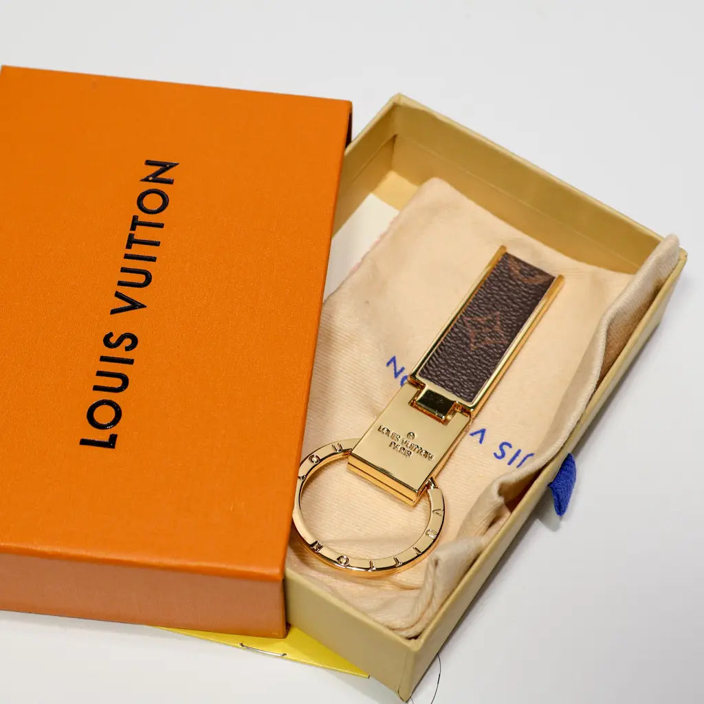 Brown folding keychain displayed on a pouch inside a box