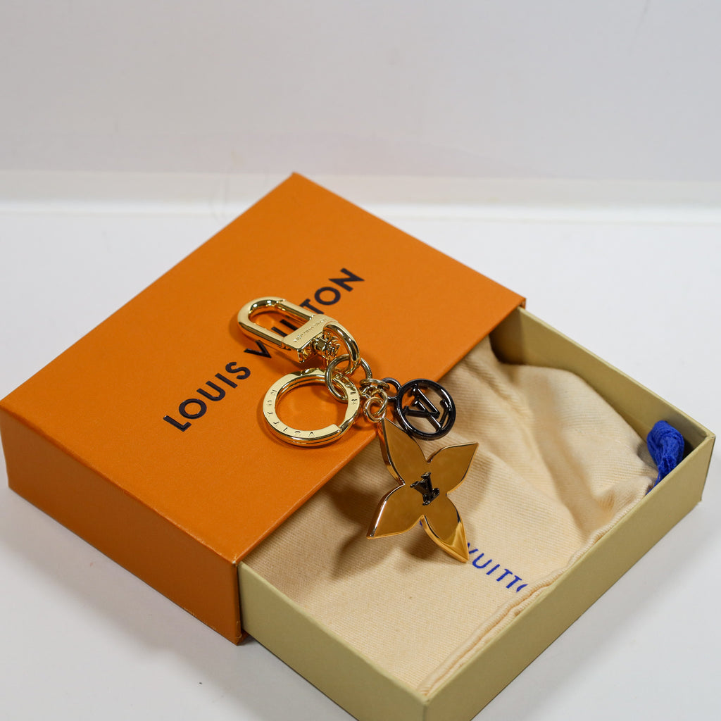 Angled view of gold-tone flower keychain over an open box