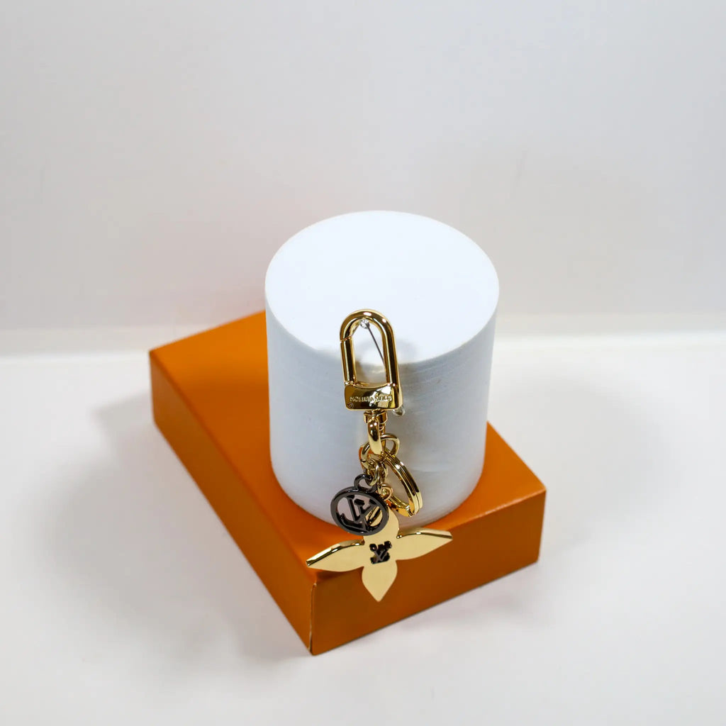 Flower keychain hanging from a white cylindrical display