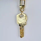 Gold-tone LV key pendant hanging vertically from its clasp