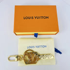 Gold-tone key charm displayed on a fabric pouch