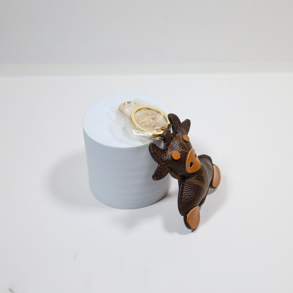 Side view of cow keychain leaning against a white display