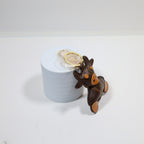 Side view of cow keychain leaning against a white display