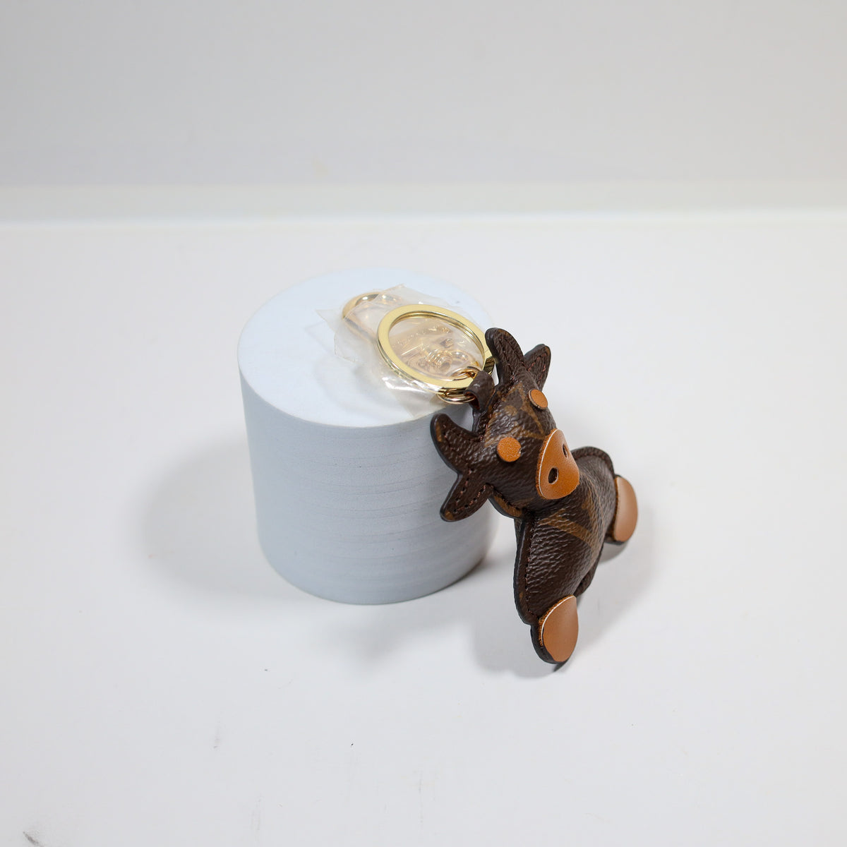 Side view of cow keychain leaning against a white display