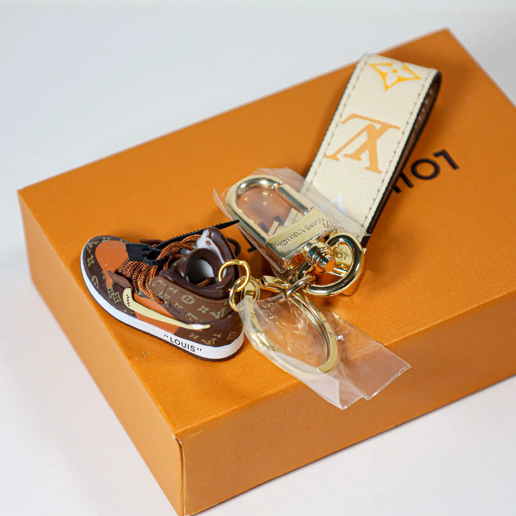 Angled view of sneaker charm and cream monogram strap