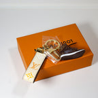 Side view of sneaker keychain with cream strap and round ring