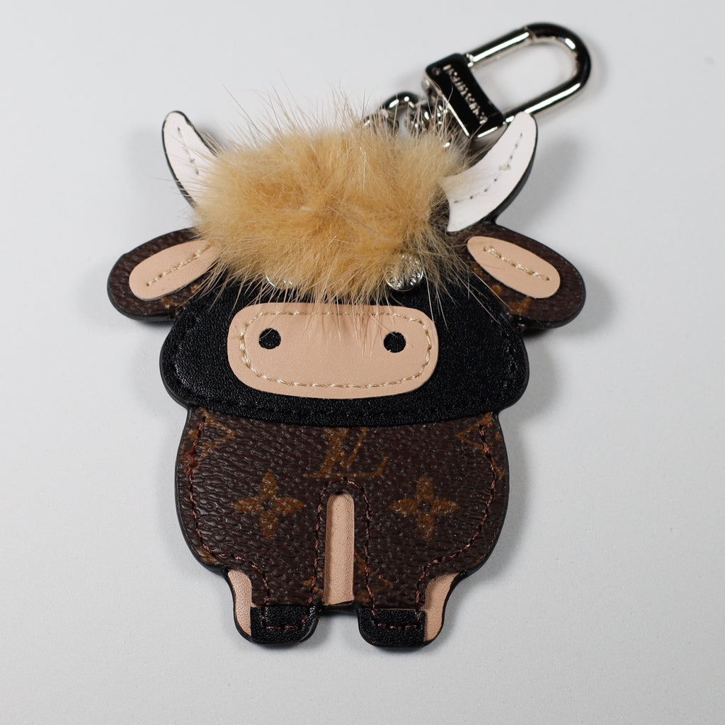 Brown monogram cow keychain with pale fluffy fringe and white horns