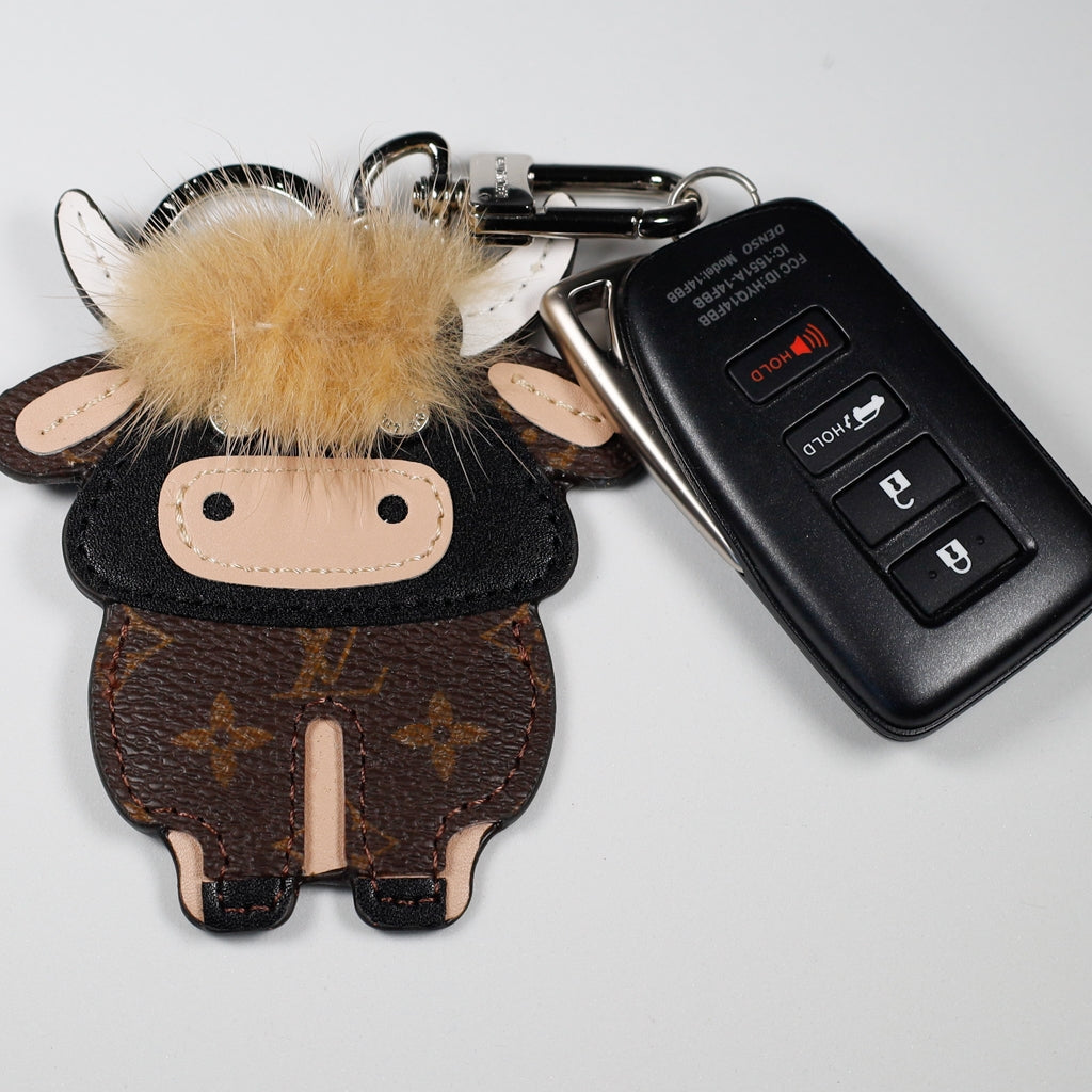 Cow keychain displayed beside a black car key
