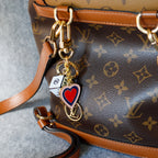 Cube and heart keychain attached to a monogram backpack