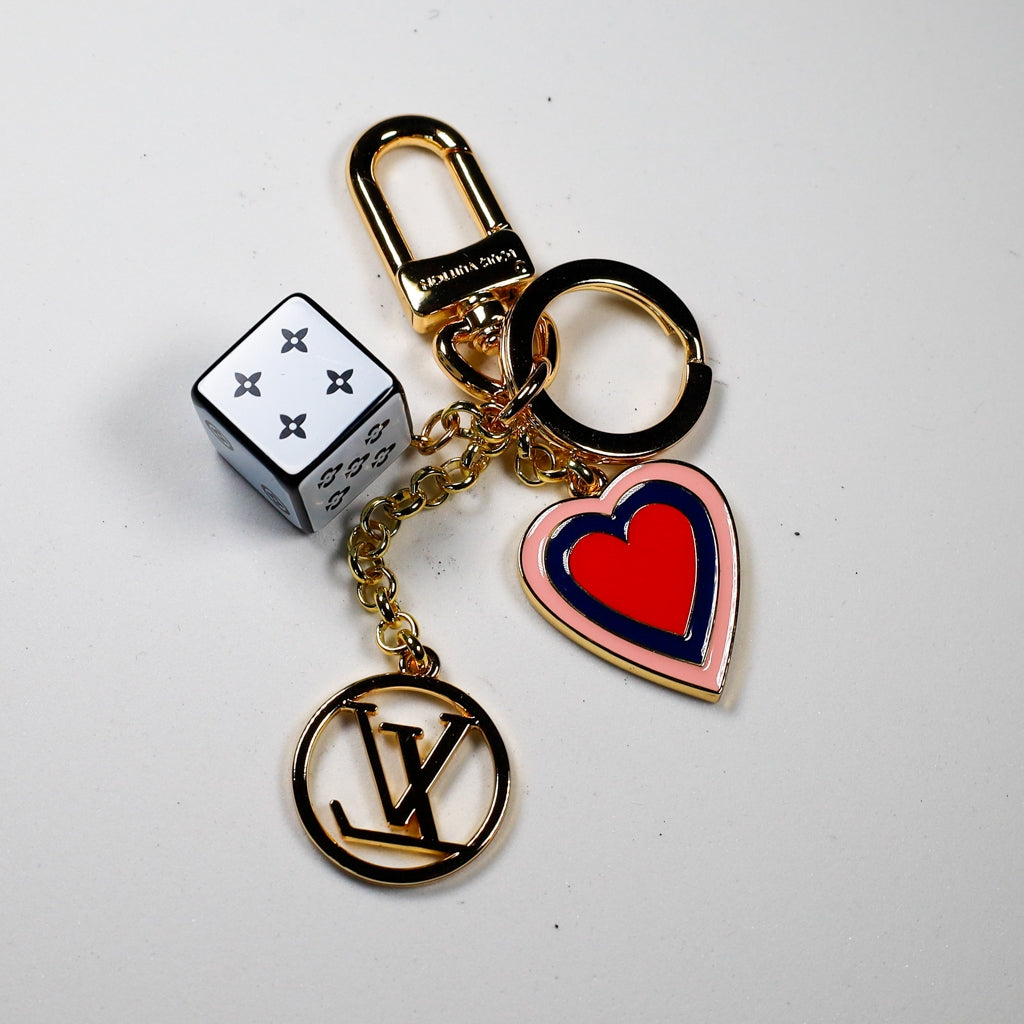 Gold-tone keychain with white cube, colorful heart, and LV pendant