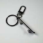 Side view of miniature skateboard keychain showing wheels