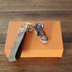 Brown sneaker keychain with tan monogram loop strap