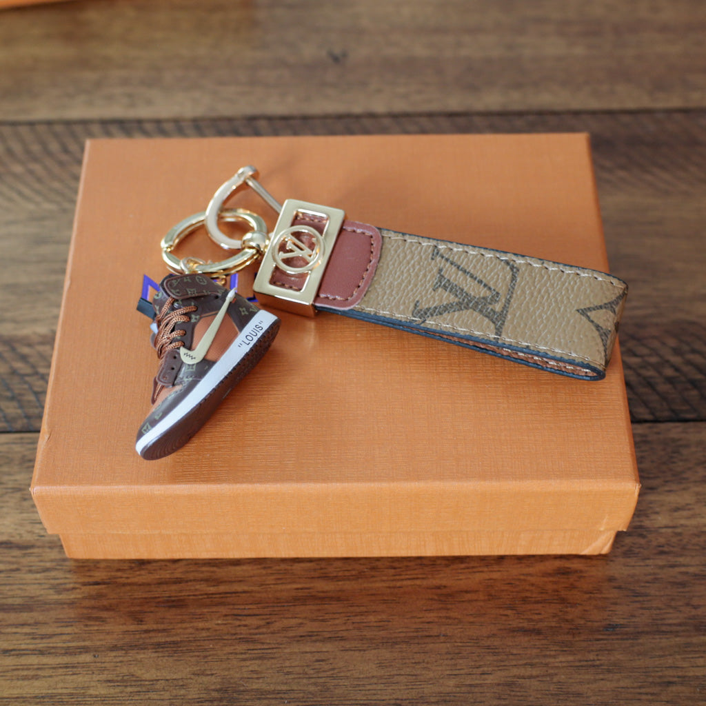 Side view of sneaker charm with tan monogram strap