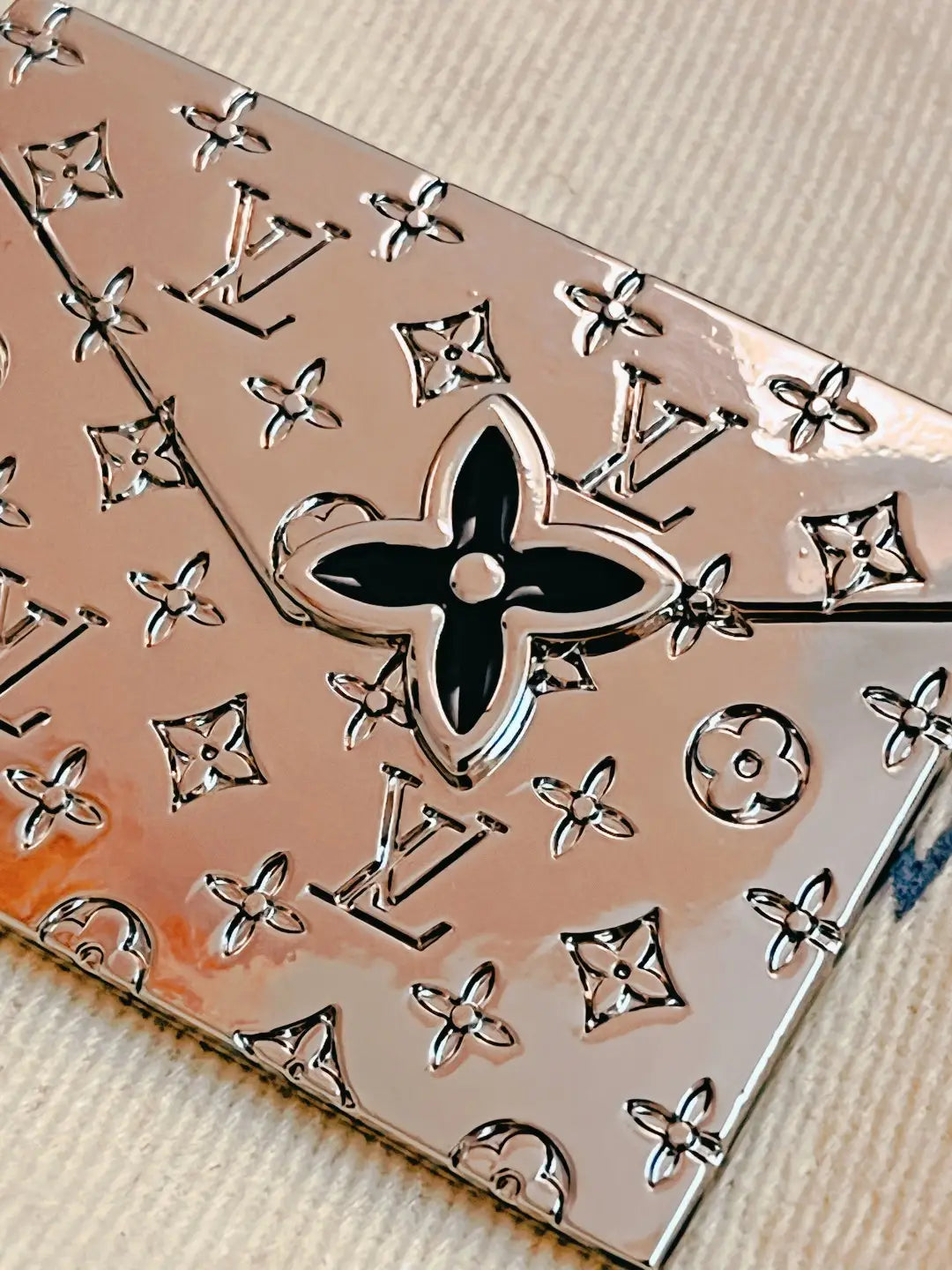 Close-up of black flower detail on silver-tone envelope pendant