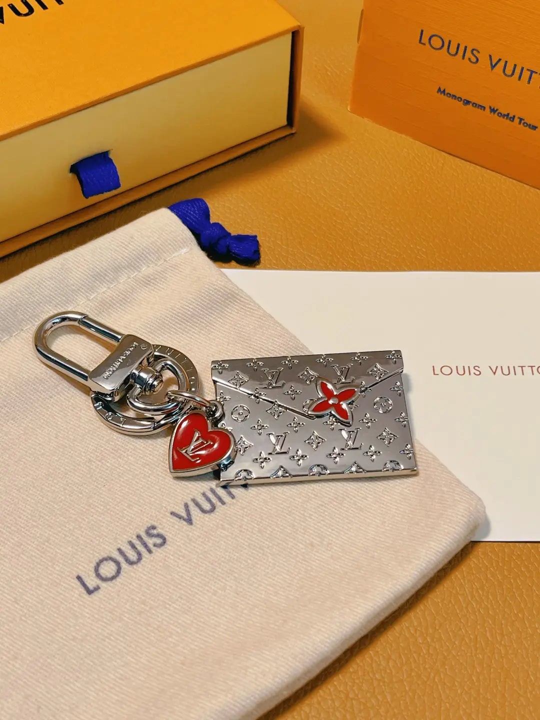 Silver-tone envelope keychain with red heart and flower details