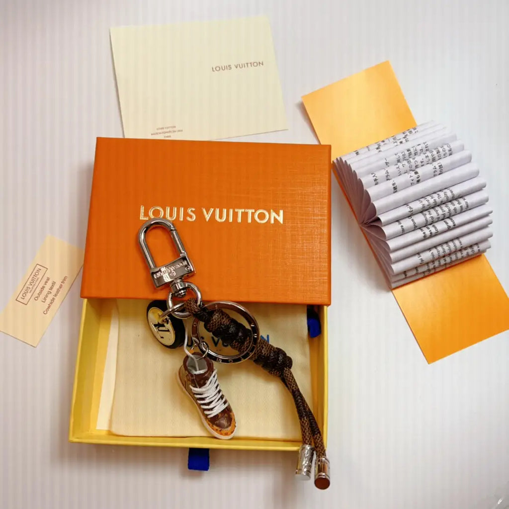 Brown sneaker keychain with braided cord shown in packaging