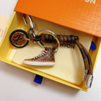 Brown monogram sneaker keychain arranged inside an orange box