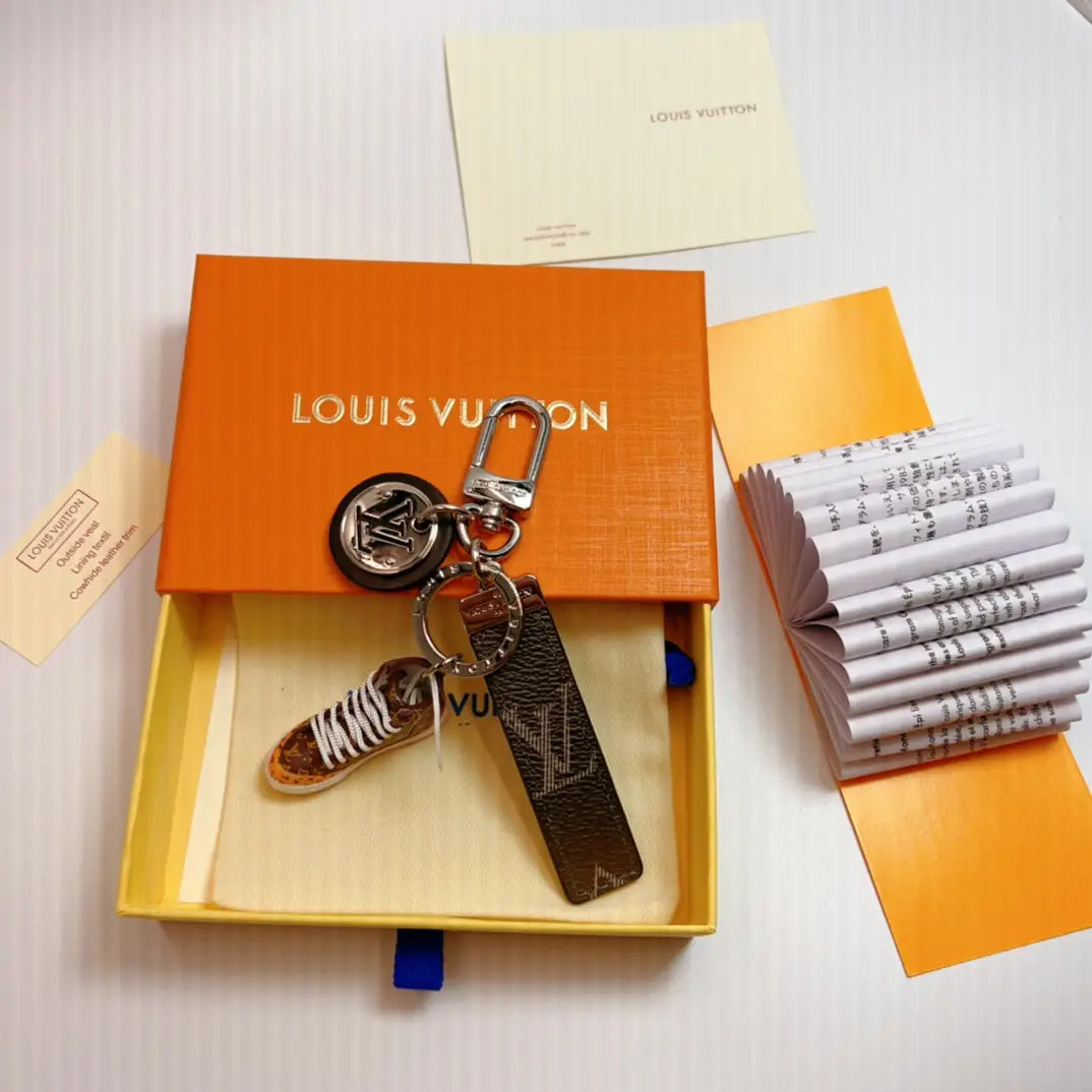 Sneaker keychain with dark monogram strap in an open box