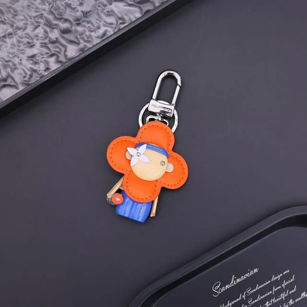 Orange flower-shaped Vivienne keychain with blue body and silver-tone clasp