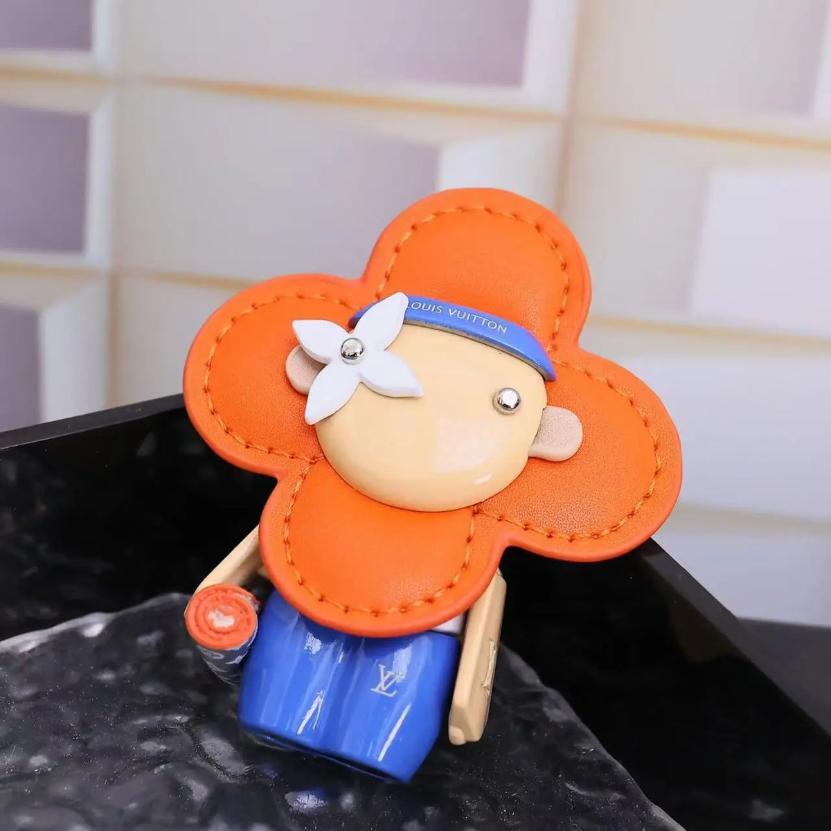 Close-up of orange Vivienne charm with white flower eye detail