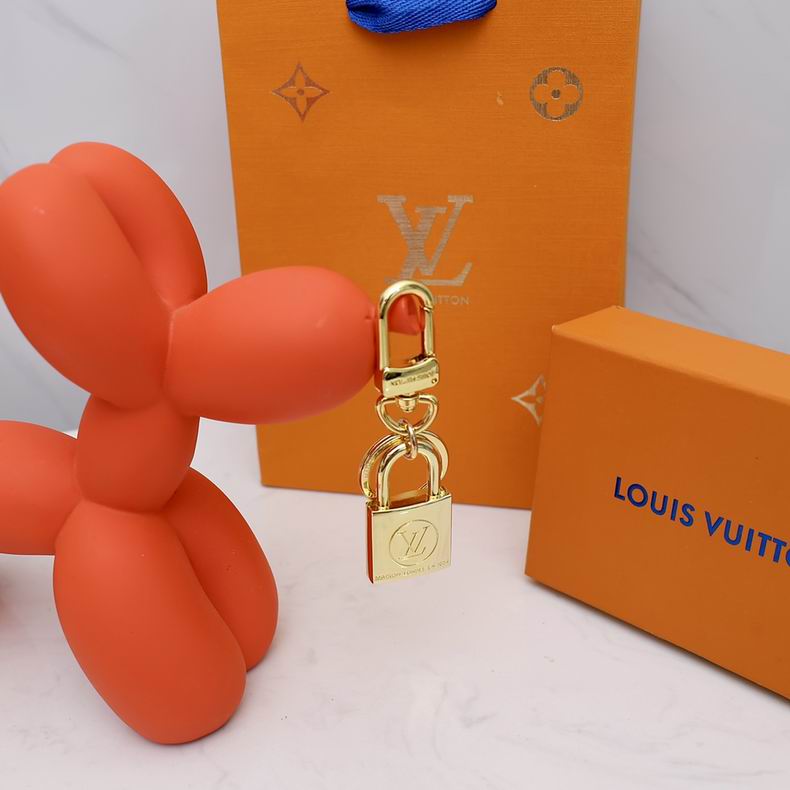 Padlock charm hanging beside orange packaging and a display ornament
