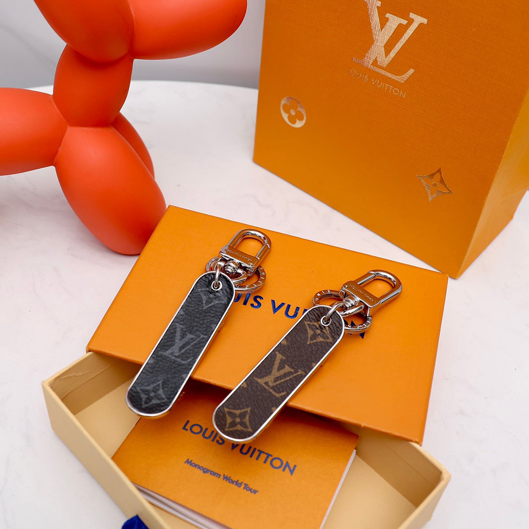 Black and brown monogram skateboard keychains with metal rings