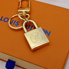 Gold-tone padlock keychain with round LV emblem