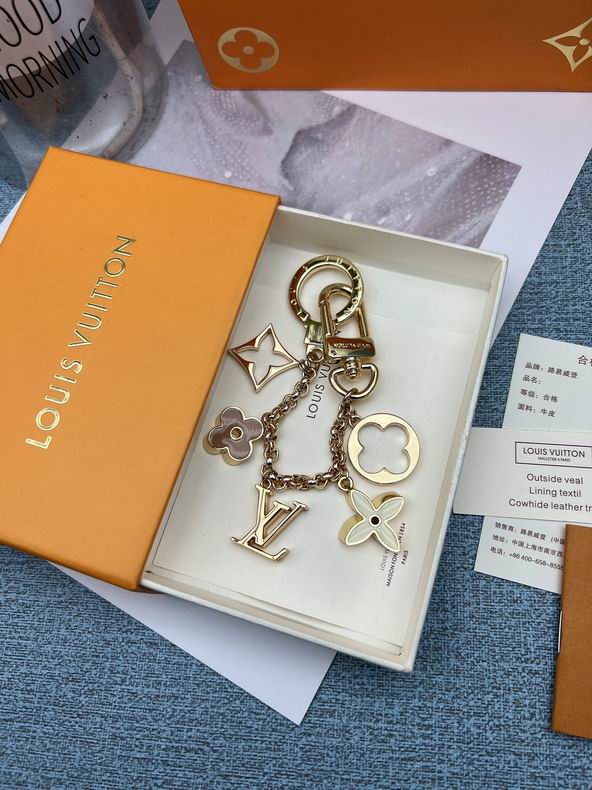 Gold-tone floral chain keychain arranged inside an orange box