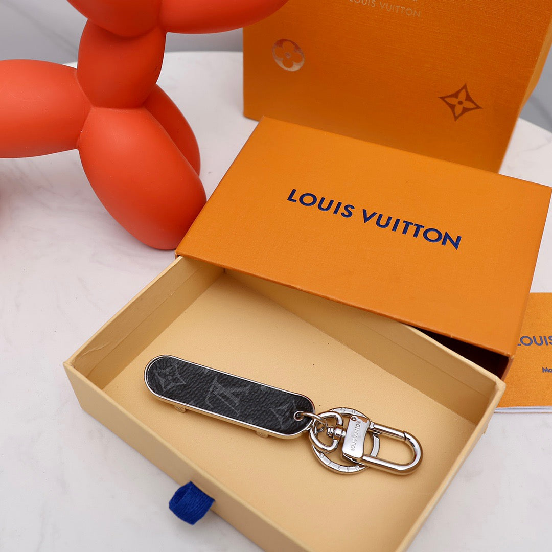Black skateboard keychain lying inside an orange box