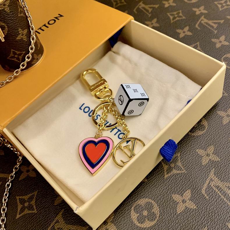 Cube and heart keychain arranged on a pouch inside a box