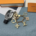 Gold-tone ornament keychain with LV and floral charms beside car key
