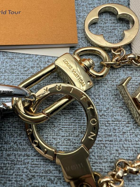 Close-up of engraved gold-tone keyring and swivel clasp