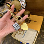 Reverse of heart charm with white cube keychain held in hand