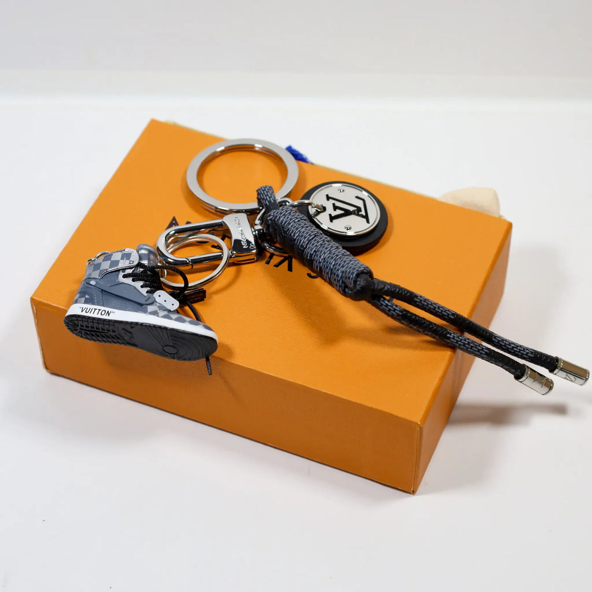Gray monogram sneaker charm with silver-tone LV medallion