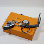 Black sneaker keychain with sole facing outward beside its cord