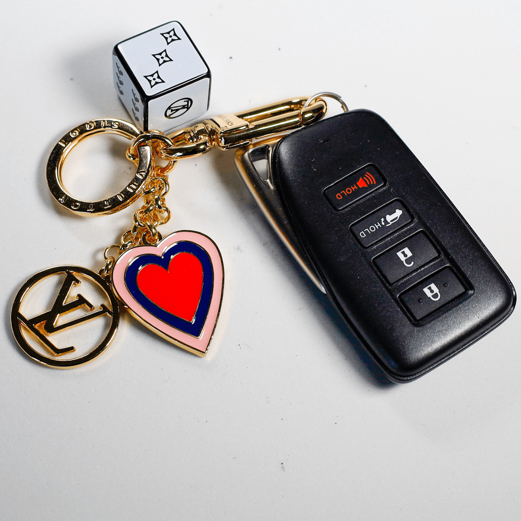 White cube keychain and red heart charm beside a car key